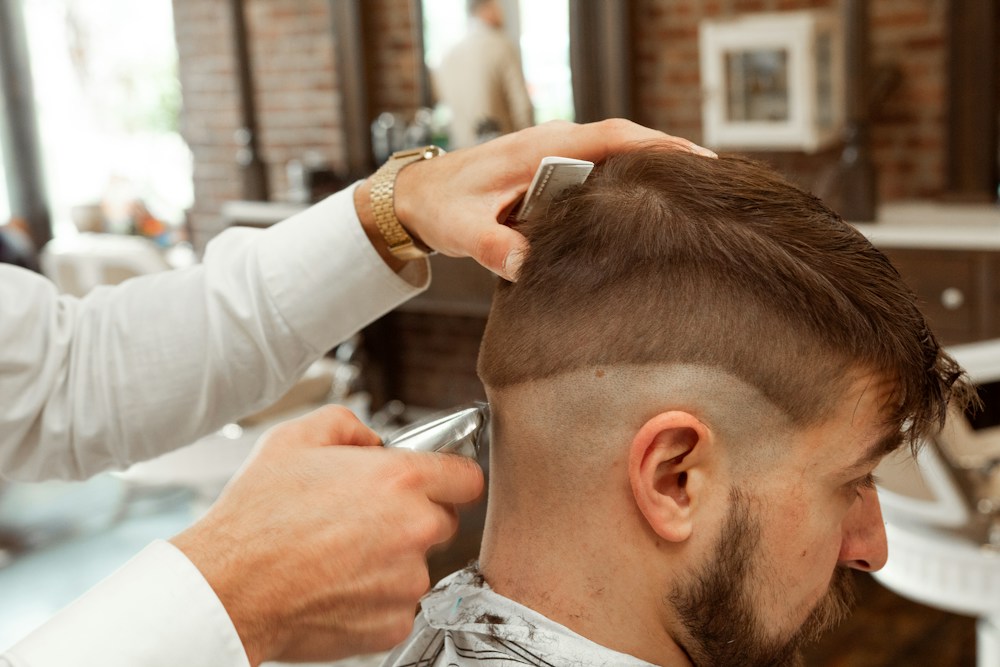 A barber finishing a fade on a client