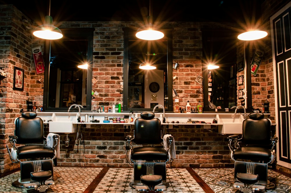 Barber chairs in front of a brick wall